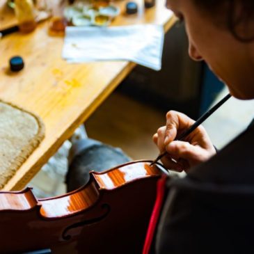 retouche de vernis sur le bord d'un violon